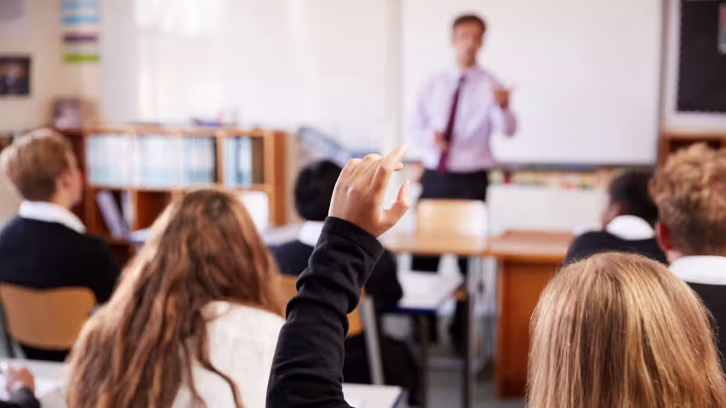 3_Female-Student-Raising-Hand-To-Ask-Question-In-Classroom.jpg
