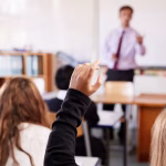 3_Female-Student-Raising-Hand-To-Ask-Question-In-Classroom.jpg