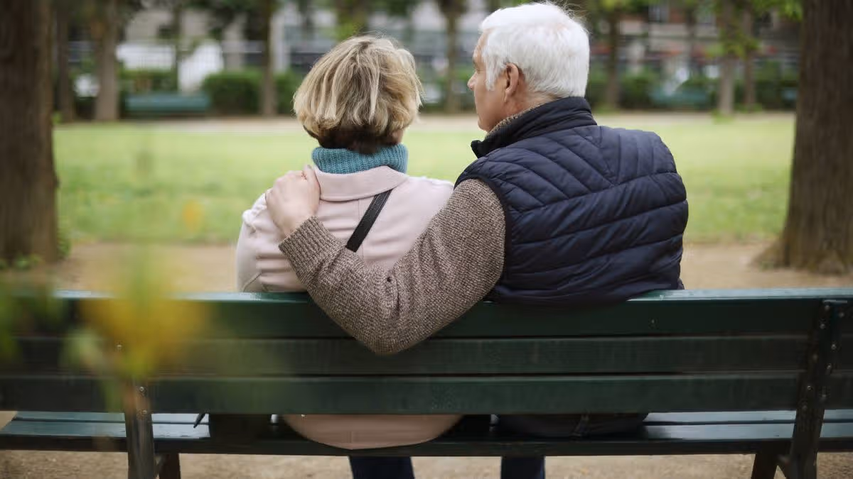 0_A-senior-couple-embracing-on-a-public-bench-in-a-park.jpg
