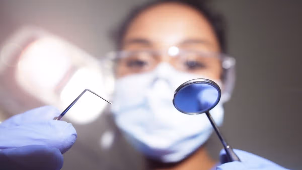 1_Dentist-looking-down-on-camera-with-tools-in-hand.jpg