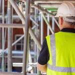 2_Rear-view-of-male-builder-construction-worker-on-building-site-wearing-hard-hat-and-hi-vis-vest.jp_.avif